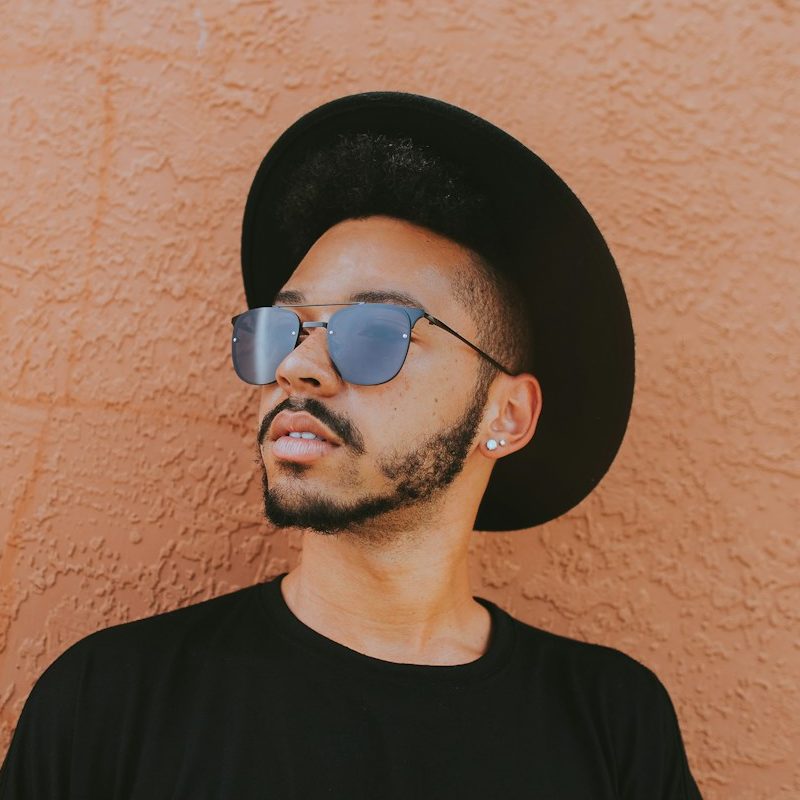 man leaning on brown wall